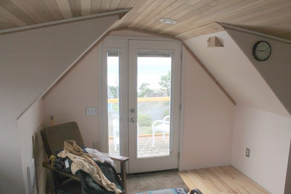 Upstairs, under the cedar ceiling. The door at the west end opens onto the balcony and the ocean. Photographed in 2014.